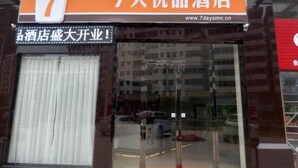 Entrada de un hotel con un letrero grande con el número '7' sobre la puerta, indicando que es el séptimo hotel de una cadena. El nombre del hotel se muestra tanto en inglés como en caracteres chinos.