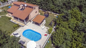 A modern house with a swimming pool, surrounded by dense greenery. - Luxury Villa Lucia with heated pool (Vodnjan)