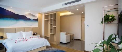 Quarto de hotel moderno com cama, mesa de cabeceira e uma janela grande.