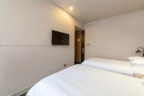 A hotel room with two beds, a flat-screen TV mounted on the wall, and a door leading to another room. - Jinjiang Inn Select (Wuhan International Expo Center Maying Road Metro Station) (Wuhan)