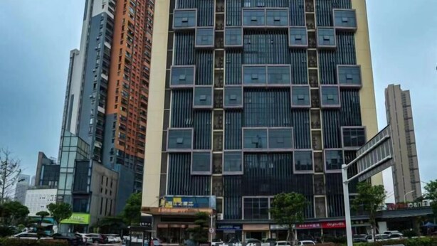 A multi-story building with a modern design, featuring a mix of glass and metal facade elements. - Jinjiang Inn Select (Wuhan International Expo Center Maying Road Metro Station) (Wuhan)