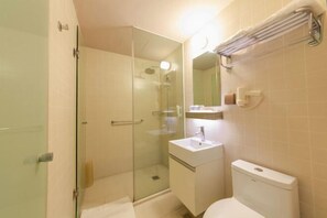 A bathroom with a glass-enclosed shower, a sink, and a toilet. - Jinjiang Inn Select (Wuhan International Expo Center Maying Road Metro Station) (Wuhan)