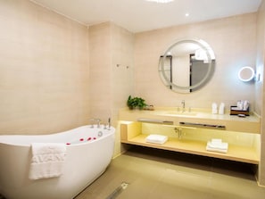A modern bathroom with a freestanding bathtub, a round mirror, and a vanity with a sink and towel rack. - Lavande Hotels (Chengdu)