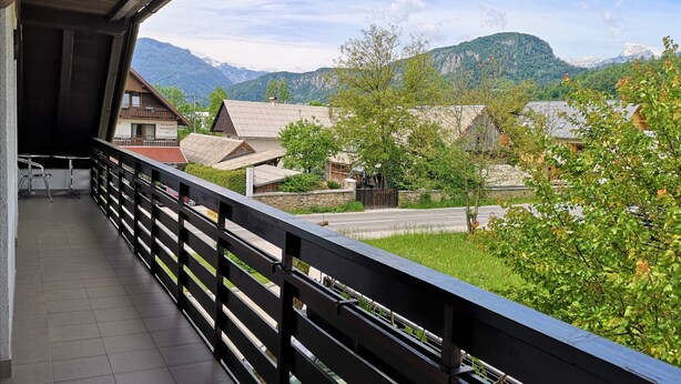 Een balkon met uitzicht op een dorp en bergen.