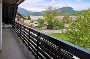 A balcony with a view of a village and mountains. - Apartments Znidar (Bohinj)