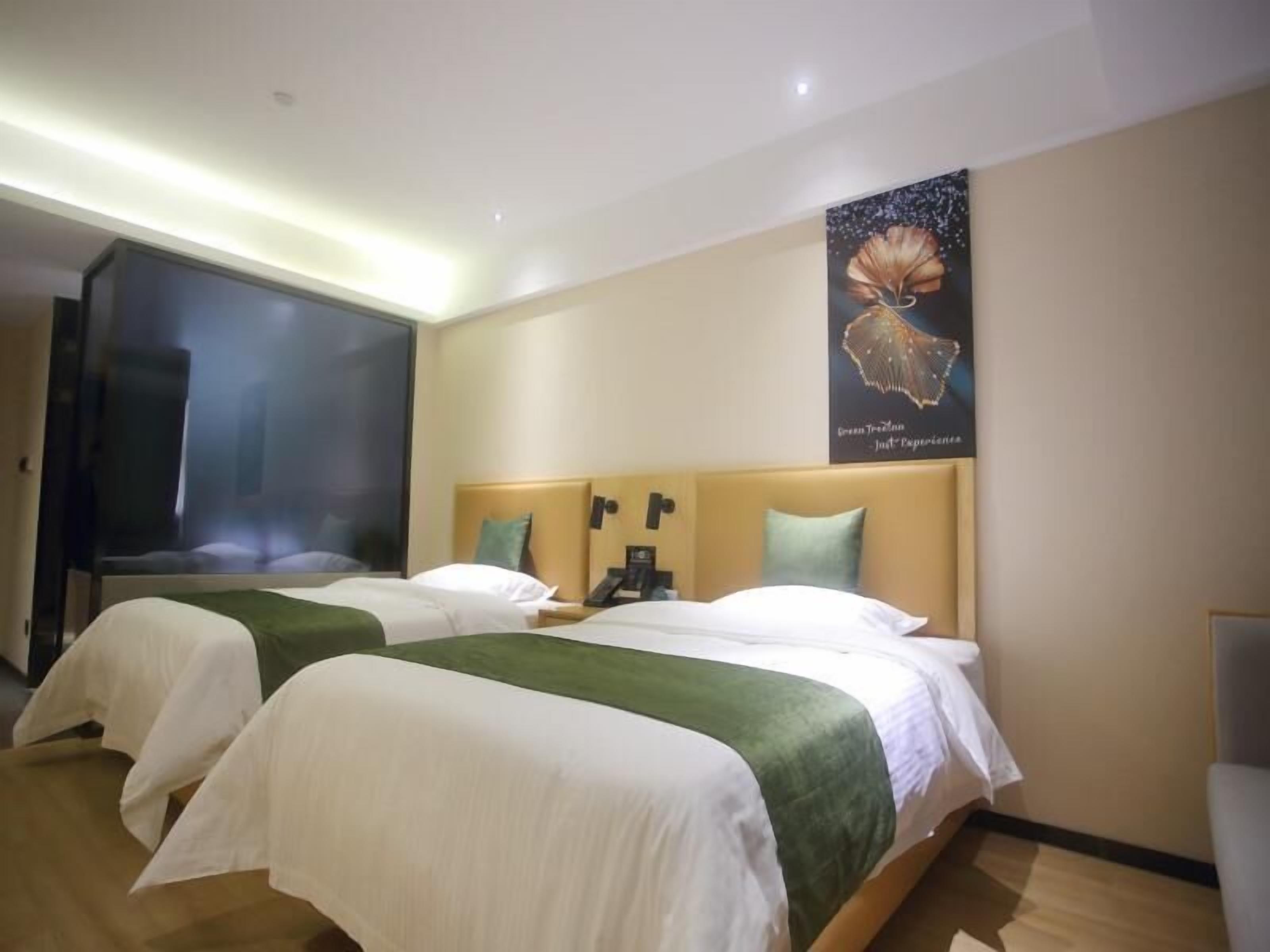 Una habitación de hotel con dos camas, un espejo grande y un cartel en la pared.