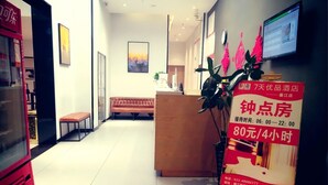 A hotel reception area with a reception desk, a bench, a welcome mat, and a signboard with room rates. - 7 Days Premium (Chongqing Qijiang District Government Shop) (Guangzhou)