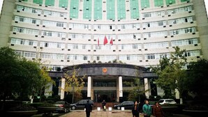 A multi-story building with a curved facade, large windows, and a central entrance with a flag. - 7 Days Premium (Chongqing Qijiang District Government Shop) (Guangzhou)
