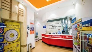 En hotellreception med en röd disk, en skylt som visar att det finns service dygnet runt och en väl synlig skylt som hänvisar till hotellets webbutik.