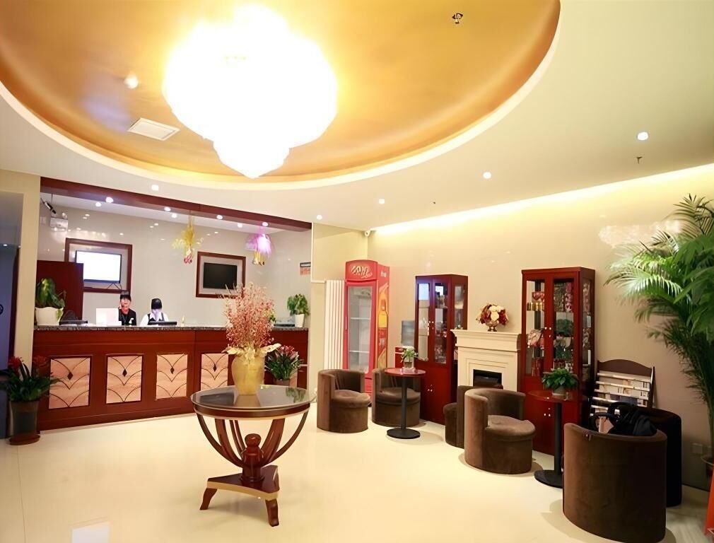 Un vestíbulo de hotel con mostrador de recepción, zona de estar y chimenea.