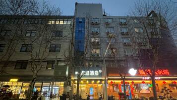 A hotel with a modern facade, multiple floors, and a ground-level restaurant.
