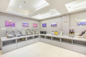 Habitación de hotel moderna con una larga encimera, varios espejos y una selección de artículos de aseo.