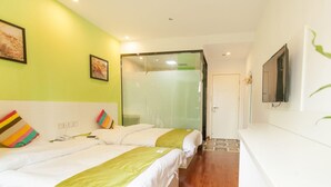 A hotel room with two beds, a green wall, a TV, and a door leading to another room. - Shell Hefei Economic Development Zone Hk Macao Squ (Hefei)