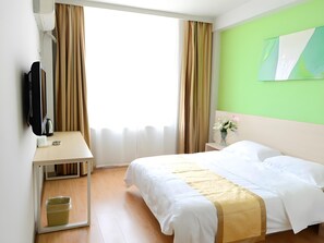 A hotel room with a bed, a desk with a flat-screen TV, a small trash bin, and a window with curtains. - Shell Shengyang Huanggu District The Yalv River Yi (Shenyang)