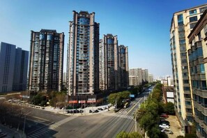 A high-rise residential building with multiple floors, a crosswalk, and a clear sky. - Baiyi Hotel (Ji'an Municipal Government Branch) (Ji'an)
