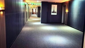 A long, narrow hotel corridor with dark walls and a carpeted floor. - Baiyi Hotel (Ji'an Municipal Government Branch) (Ji'an)