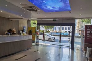 A hotel reception area with a modern design, a reception desk, and a view of the street outside. - Baiyi Hotel (Ji'an Municipal Government Branch) (Ji'an)