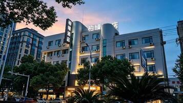 A multi-story hotel with a modern design, featuring a prominent vertical structure and signage.