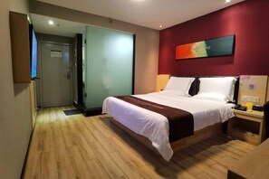 Une chambre d’hôtel avec un lit, un bureau, une chaise, une télévision et un tableau au mur.