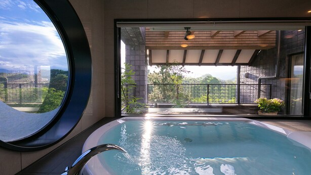 A modern indoor swimming pool with a view of greenery and a balcony.