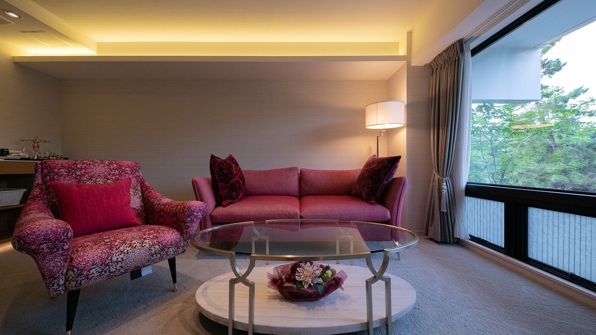 Ein Wohnzimmer mit Sofa, Sessel und einem Glastisch.