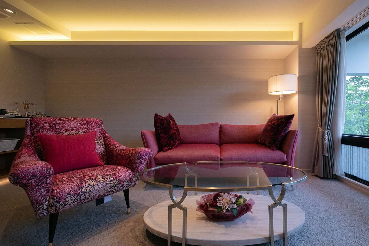 Un salon avec un canapé, un fauteuil et une table basse en verre.