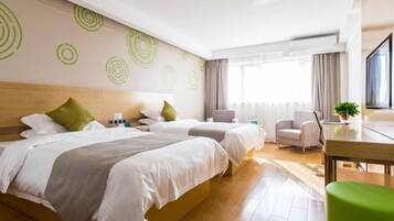 A hotel room with a large bed, two bedside tables, a desk, a chair, and a window with curtains.