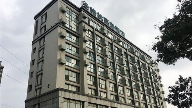A multi-story hotel with a modern architectural design, featuring a prominent entrance and signage. - Greentree Inn Yancheng Tinghu Area Wanda Square Br (Yancheng)