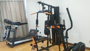 A home gym with a treadmill, bench press, and elliptical. - Greentree Inn Yancheng Tinghu Area Wanda Square Br (Yancheng)