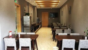 A conference room with a long table and chairs, a refrigerator, a television, and a door at the end. - Greentree Inn Yancheng Tinghu Area Wanda Square Br (Yancheng)