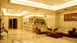 A hotel lobby with a reception desk, seating area, and a large painting on the wall. - Greentree Inn Weifang Kuiwen District Beiwang Jial (Weifang)