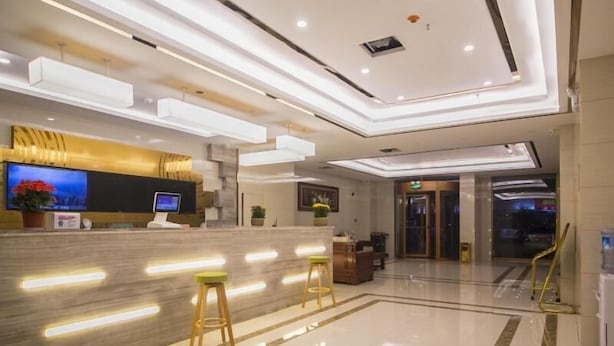 A modern hotel lobby with a reception desk, seating area, and a large screen. - Greentree Inn Weifang Kuiwen District Beiwang Jial (Weifang)