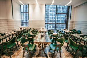 A conference room with multiple tables and chairs, large windows with a city view, and a modern interior design. - Lavande Hotel Chongqing Tongliang Gas Building (Chongqing)