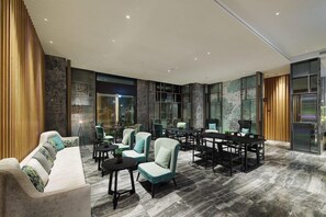 Un interior moderno con una mesa larga de comedor, varias sillas y un sofá.