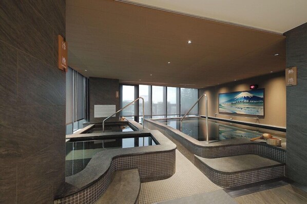A modern spa area with two hot tubs, a wooden bench, and a painting of Mount Fuji. - Jasper Hotel Banqiao Taipei (New Taipei City)