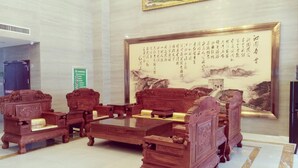 A traditional wooden furniture arrangement with a large framed calligraphy artwork on the wall. - Greentree Inn Luoyang Train Station Zhuangyuanhong (Luoyang)