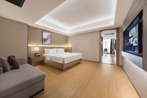 A modern hotel room with a bed, a sofa, a desk, and a TV. - LAVANDE HOTELS (Chaozhou)