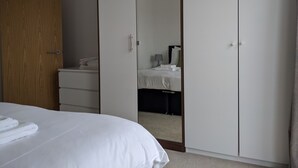 A hotel room with a bed, a wardrobe, and a mirror. - Nidus Flat (Cambridge)