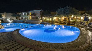 A swimming pool with a circular design, surrounded by a paved deck. - Stefan Village Hotel (Chania)