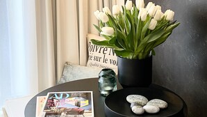 A modern interior with a round table displaying a magazine, a potted plant, and decorative stones. - Grace-Design-Apartment Deluxe in the center of Munich, top location (München)