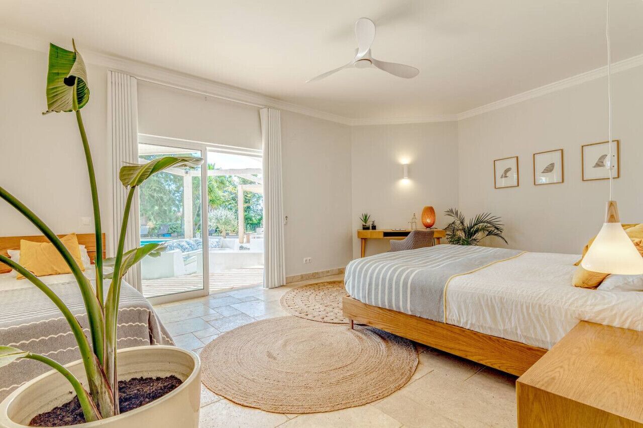 Un dormitorio moderno con una cama grande, un ventilador de techo y vistas al exterior.
