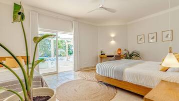 Un dormitorio moderno con una cama grande, un ventilador de techo y vistas al exterior.