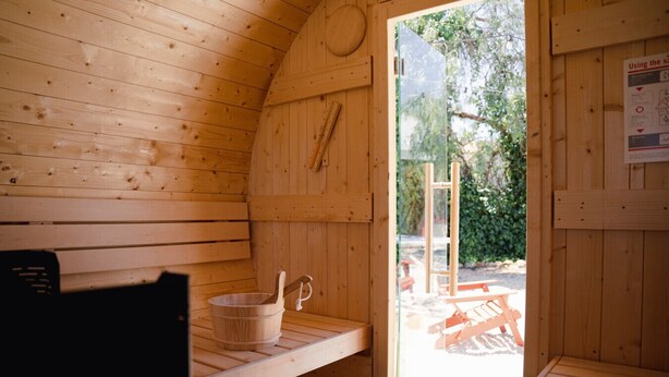 A wooden sauna with a bench, a bucket, and a towel rack. - The Eden Lodge, a unique space for groups (Lagos)