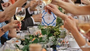 A group of people toasting with wine glasses at a table with a floral centerpiece. - The Eden Lodge, a unique space for groups (Lagos)