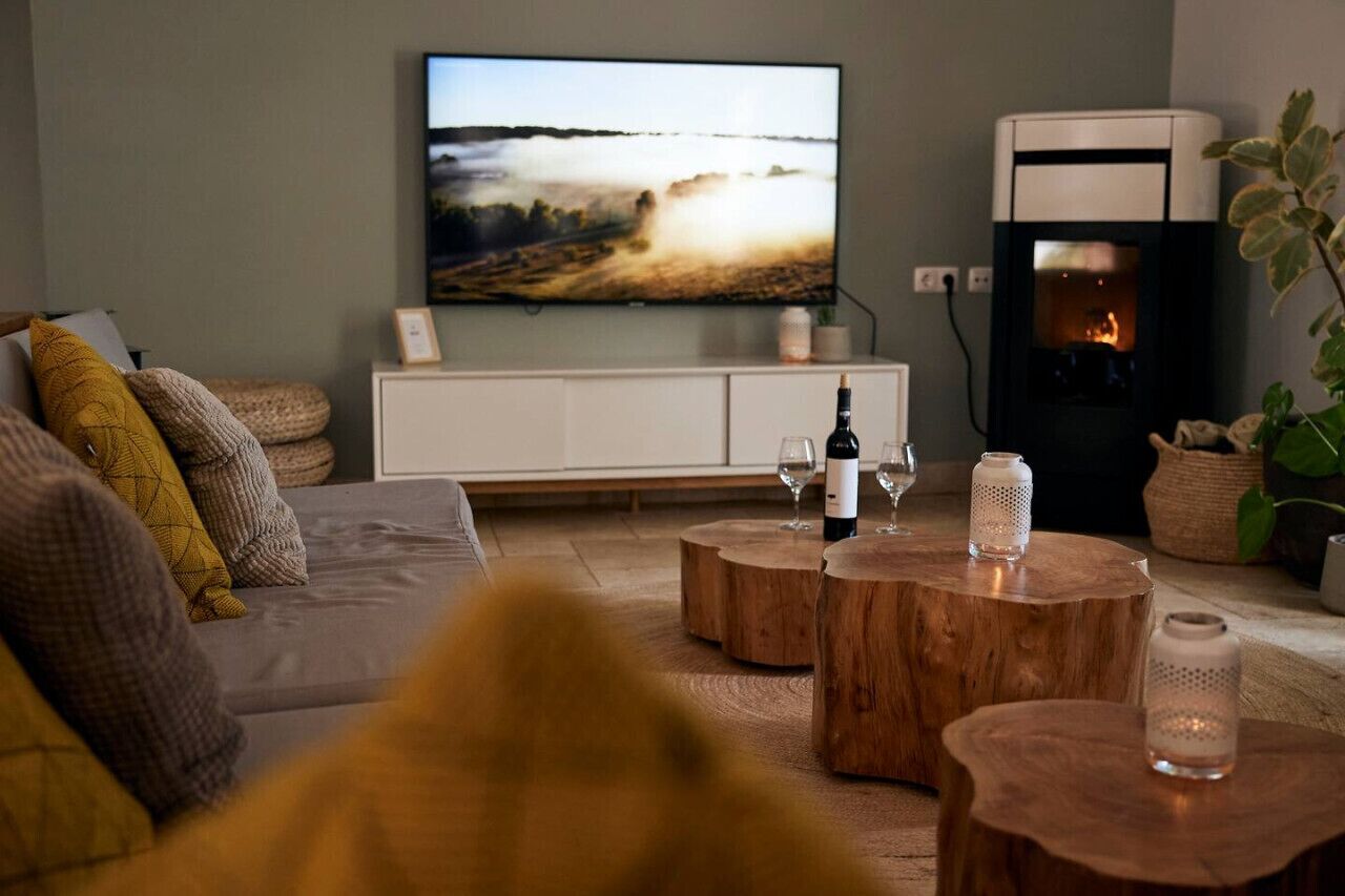 A living room with a television, a fireplace, and a sofa.