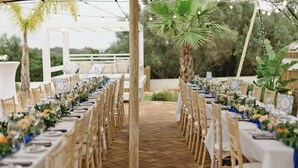 An outdoor dining area with long tables, chairs, and string lights. - The Eden Lodge, a unique space for groups (Lagos)