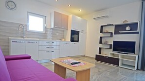 A modern kitchen with white cabinets, a built-in oven, and a window above the sink. - Apartment with sea view and next to the beach (20m) (Betina)