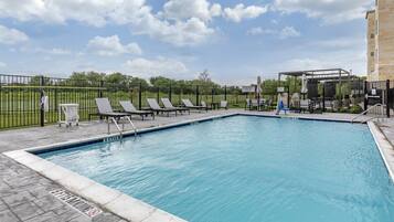Una piscina al aire libre de temporada, sillones reclinables de piscina
