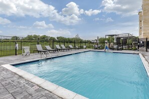 Relax by the pool surrounded by a deck and lounge chairs.