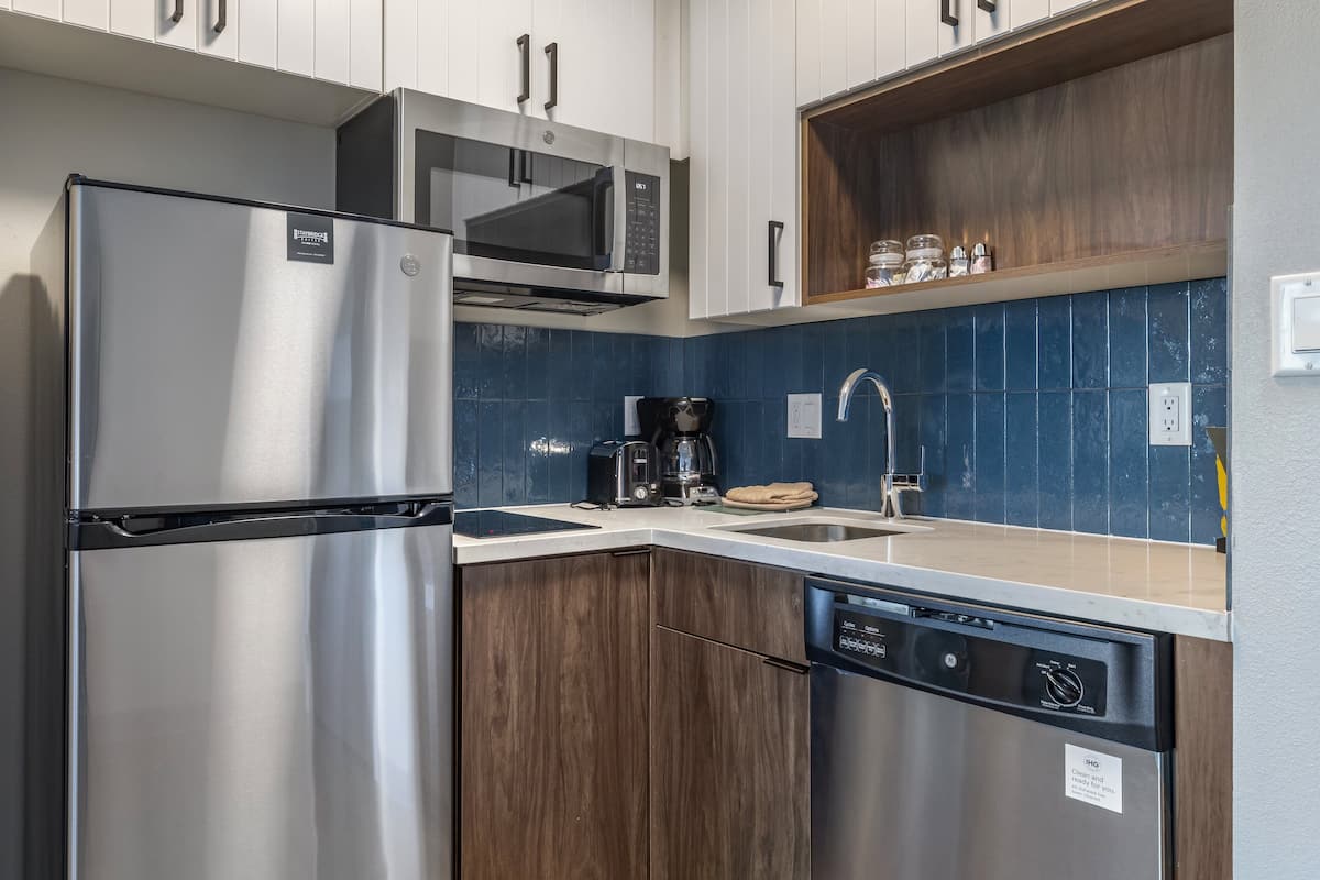 A modern kitchen with stainless steel appliances, a dishwasher, and a coffee maker.